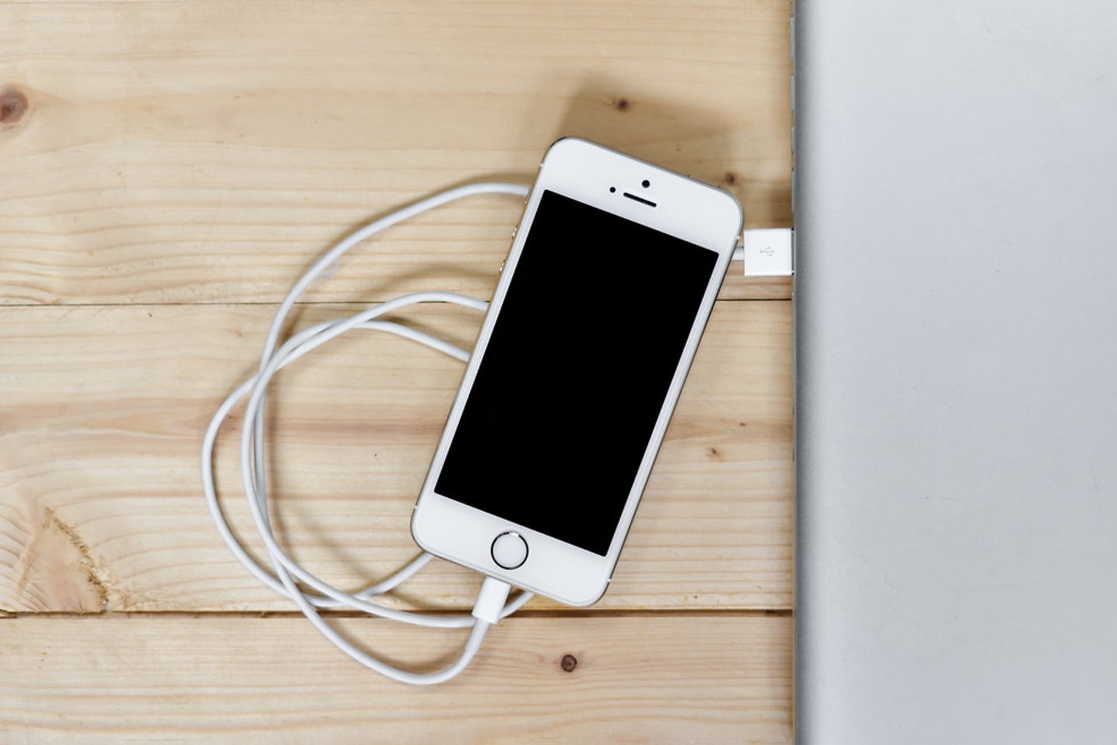 iPhone resting on a wooden desk